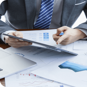Finansal belgeler üzerinde tablet inceleyen takım elbiseli iş insanı.